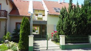 una casa con un cancello e alberi di fronte di Gere MODERN Apartment a Harkány