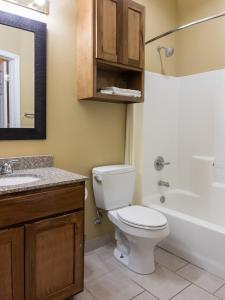 a bathroom with a toilet and a sink and a tub at Bungalows Hotel & Hotel Que at Lakeline Austin Cedar Park in Cedar Park