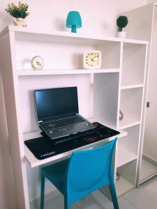 a laptop computer sitting on a desk with a blue chair at Palm Village - Porto de Galinhas/Cupe/Muro Alto in Porto De Galinhas