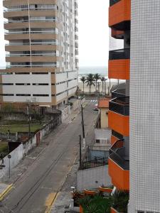 uma rua da cidade vazia com edifícios e o oceano em Apto Praia Grande - 50 metros da praia em São Paulo