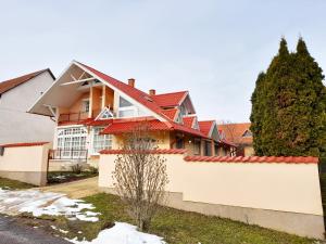 una casa con techo rojo y valla blanca en Mátra Wellness Vendégház, en Parádsasvár