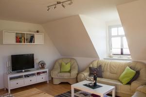 ein Wohnzimmer mit 2 Sofas und einem TV in der Unterkunft Ferienwohnung Marschblick in Mildstedt