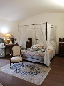 ein Schlafzimmer mit einem Bett, einem Stuhl und einem Schreibtisch in der Unterkunft Lavanda E Merletti Maison De Charme in Montoro Inferiore
