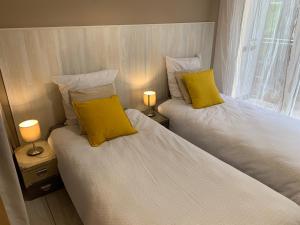 カンヌにあるClose Palais - Calm - Brand Newの黄色い枕付きのベッド2台が備わる客室です。
