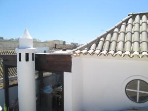 ein weißer Leuchtturm auf dem Dach eines Gebäudes in der Unterkunft Guest House Capitao Mor in Faro