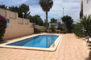 a swimming pool in a yard with a palm tree at Ático a 200m del mar. in Jávea