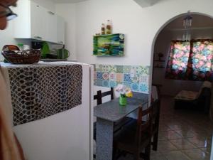 a kitchen with a small table and a refrigerator at Recanto dos Pássaros Olivença in Ilhéus