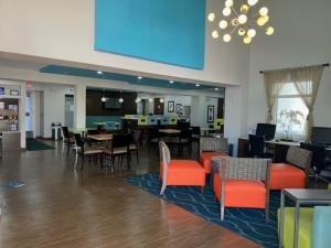 restauracja ze stołami i krzesłami oraz jadalnią w obiekcie La Quinta by Wyndham Oceanfront Daytona Beach w mieście Daytona Beach