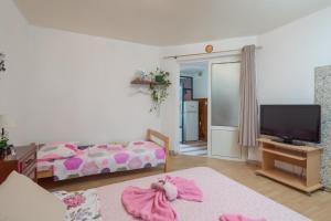 a living room with a bed and a television at Guest house Ivona in Split