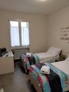 a bedroom with two beds and a desk and a window at Braschi 8 B&B in Zola Predosa