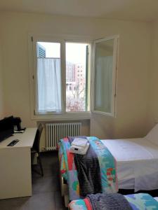 a hotel room with two beds and a desk and a window at Braschi 8 B&B in Zola Predosa