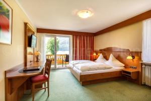 um quarto de hotel com uma cama e uma secretária em Haus Jäger Ferienwohnungen mit Indoor-Pool em Ruhpolding
