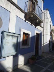 niebiesko-biały budynek z oknem i balkonem w obiekcie Casa Celeste w mieście Lipari
