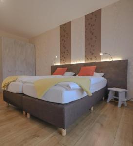 ein Schlafzimmer mit einem großen Bett mit roten und gelben Kissen in der Unterkunft Gasthaus zur Quelle in Bad Marienberg