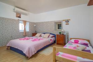 a bedroom with two beds with pink sheets at Guest house Ivona in Split