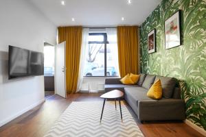 ein Wohnzimmer mit einem Sofa und einem TV in der Unterkunft Maria und Joseph Apartments in Innsbruck