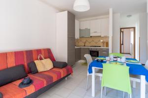 ein Wohnzimmer mit Couch und Tisch und eine Küche in der Unterkunft Cavalluccio Marino i1 Silvi Vacanza in Silvi Marina