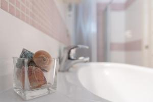 Ein Badezimmerwaschbecken mit einer Glasvase auf der Ablage in der Unterkunft Green Marine L2 Silvi Vacanza in Silvi Marina