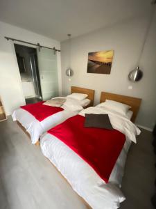 - une chambre avec 2 lits dotés de draps rouges et blancs dans l'établissement Relais de l'Aérodrome, à Prangins