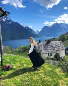 een vrouw in een lange zwarte rok in het gras bij Tunold Gård - Kårhus in Mindresunde