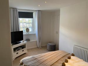 a bedroom with a bed and a flat screen tv at The Nook Devon Square in Kingsbridge
