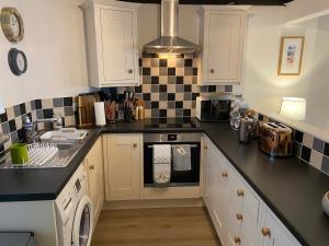 a kitchen with black and white tiles on the wall at The Nook Devon Square in Kingsbridge