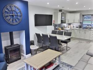 a kitchen and living room with a clock on the wall at Cranfield Cottage by the Sea 4 star NITB approved in Kilkeel