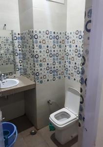 a bathroom with a toilet and a sink at Hotel Ishan in Katra