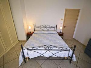 a large bed in a room with two lamps on tables at Fuori Rotta Holiday Home in Maruggio