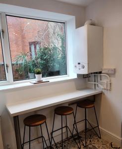 a kitchen counter with two stools under a window at Ouse View Cottage in Goole