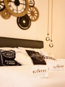 um quarto com uma cama com um relógio na parede em Olympus Luxury Suites em Mola di Bari