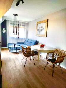 uma sala de estar com uma mesa e cadeiras e um sofá em Apartament Klimatyzowany Teren Ośrodka Sun&Snow Białka Tatrzańska em Białka Tatrzanska
