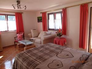 a bedroom with a bed and a living room at Haus Neuhäusl inkl. Chiemgaukarte in Ruhpolding