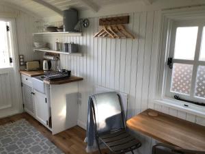 a kitchen with a desk and a chair in a room at The Hut by the River in York +10 photos