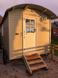 a small shed with a door and a ladder at The Hut by the River in York