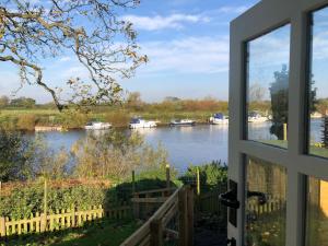 a window view of a river with boats in it at The Hut by the River in York
