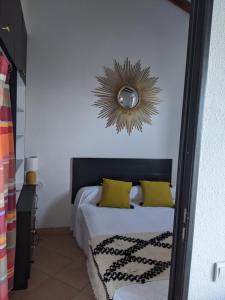 サン・シプリアンにあるAppartement Jolie vueのベッドルーム1室(黄色い枕と鏡付きのベッド1台付)