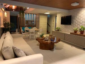 - un salon avec un canapé et une table dans l'établissement Bangalô Luxo Praia dos Carneiros, à Praia dos Carneiros
