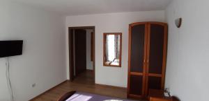 ein Wohnzimmer mit einem Schrank und einem Spiegel in der Unterkunft Guest House Raffe in Dobrinischte
