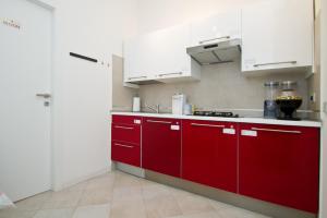 a red and white kitchen with white cabinets at B&B Trieste Plus in Trieste