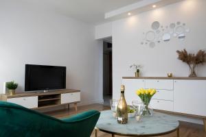 a living room with a green couch and a tv at Luxus Apartament Sea View Gdynia in Gdynia