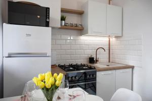 a kitchen with yellow tulips in a vase on a table at Luxus Apartament Sea View Gdynia in Gdynia