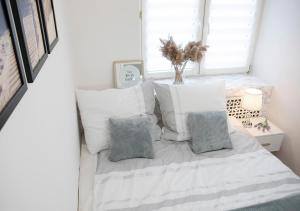 a bedroom with a white bed with pillows and a window at Luxus Apartament Sea View Gdynia in Gdynia