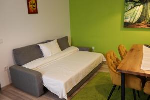 a small bedroom with a bed and a table at Apartamente Bucegi in Râşnov