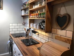 een keuken met een aanrecht met een wastafel en een fornuis bij Heather Cottage Bakewell in Bakewell