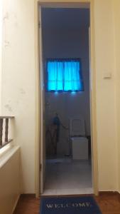 eine Tür zu einem Zimmer mit blauem Fenster in der Unterkunft Los Cuartos Man Pretinha in Tarrafal