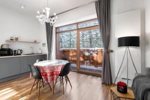 una cucina e un soggiorno con tavolo e sedie di Willa Jarosta a Zakopane