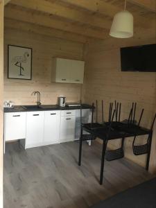 - une cuisine avec une table, une table et des chaises dans l'établissement Domki Letniskowe Kaja, à Rewal