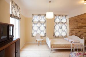 1 Schlafzimmer mit einem Bett und 2 Fenster mit Vorhängen in der Unterkunft Aia Guest Apartment in Pärnu