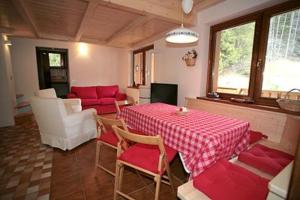 a living room with a red table and chairs at Residence Anny in Canazei